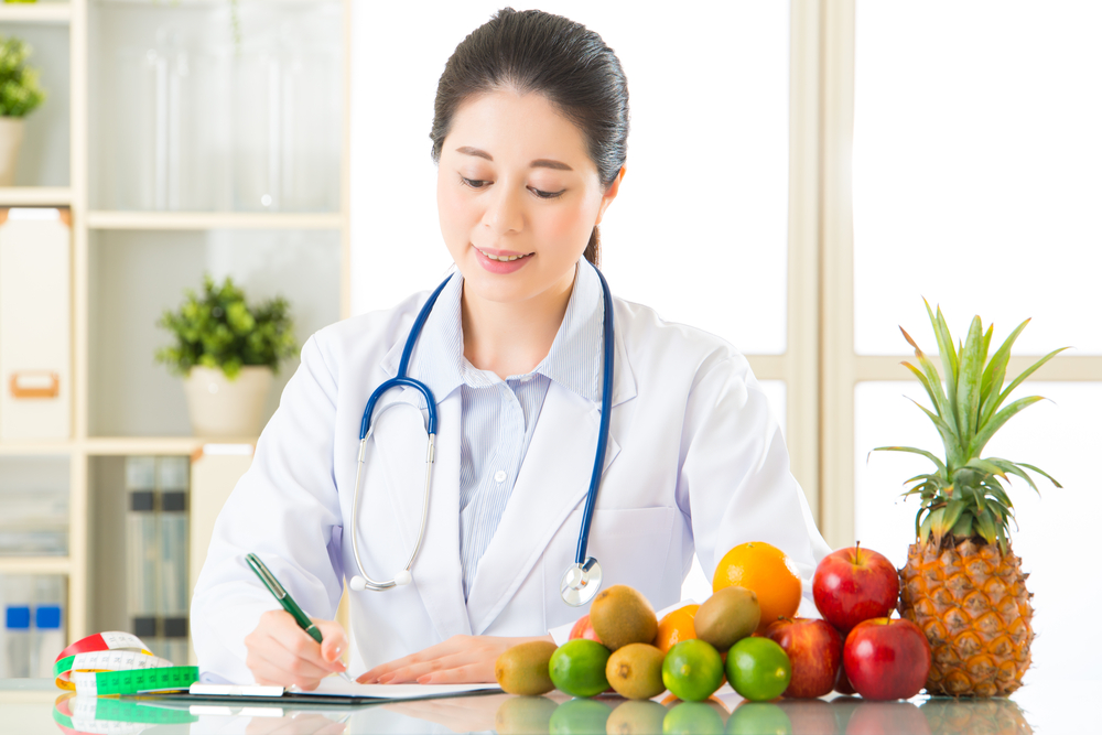 果物に関する栄養指導の書類を作成する管理栄養士の女性